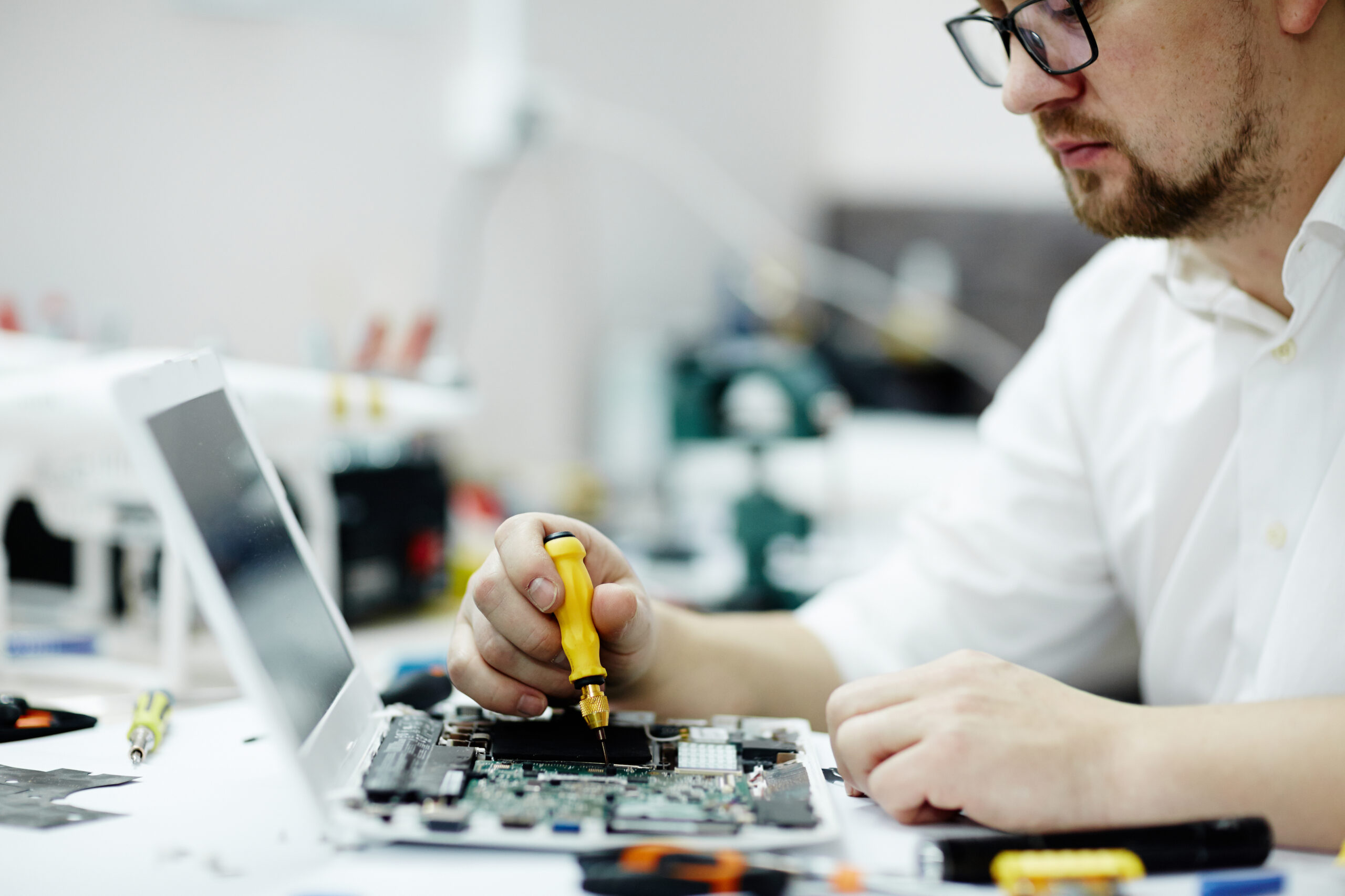 man assembling circuit board laptop scaled VIP Systems